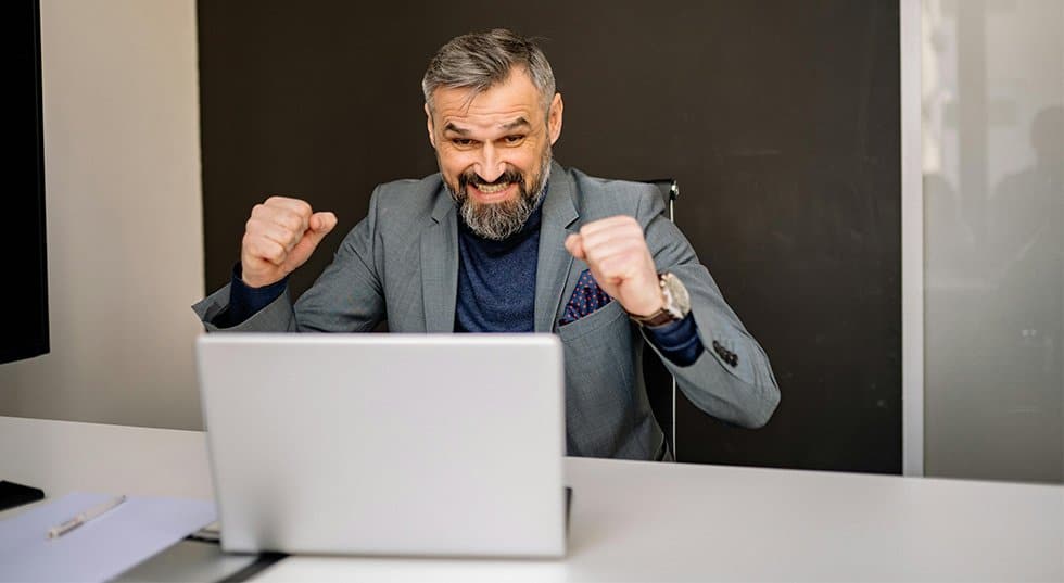 homme-jubile-ordinateur homme d'affaire qui jubile devant son ordinateur